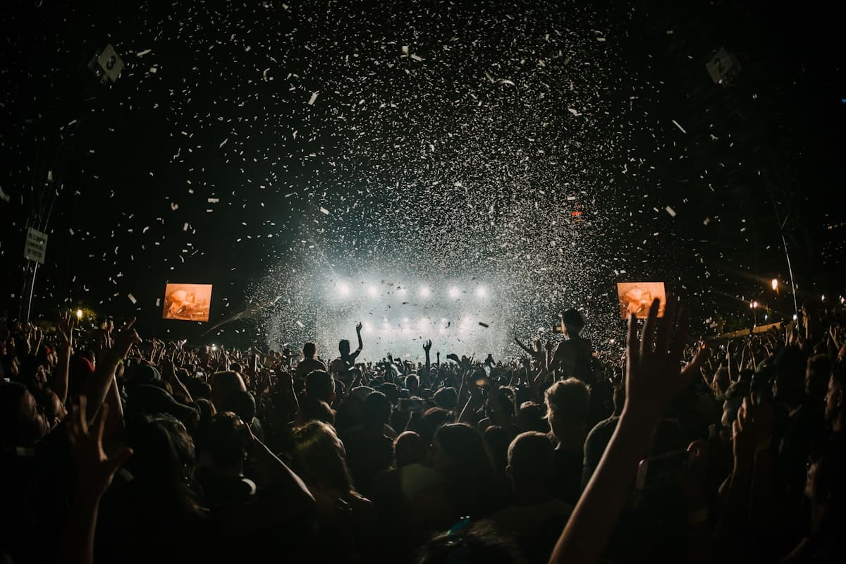 Nächtliche Festivalbühne mit hellem Gegenlicht und Konfetti über dem Publikum